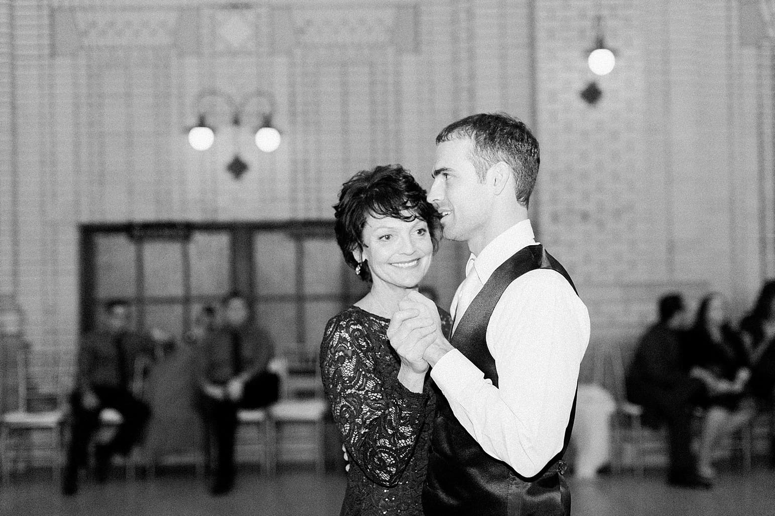 Arielle Peters Photography | Mother of groom and groom dancing at wedding reception at Baker Street Train Station in Fort Wayne, Indiana.