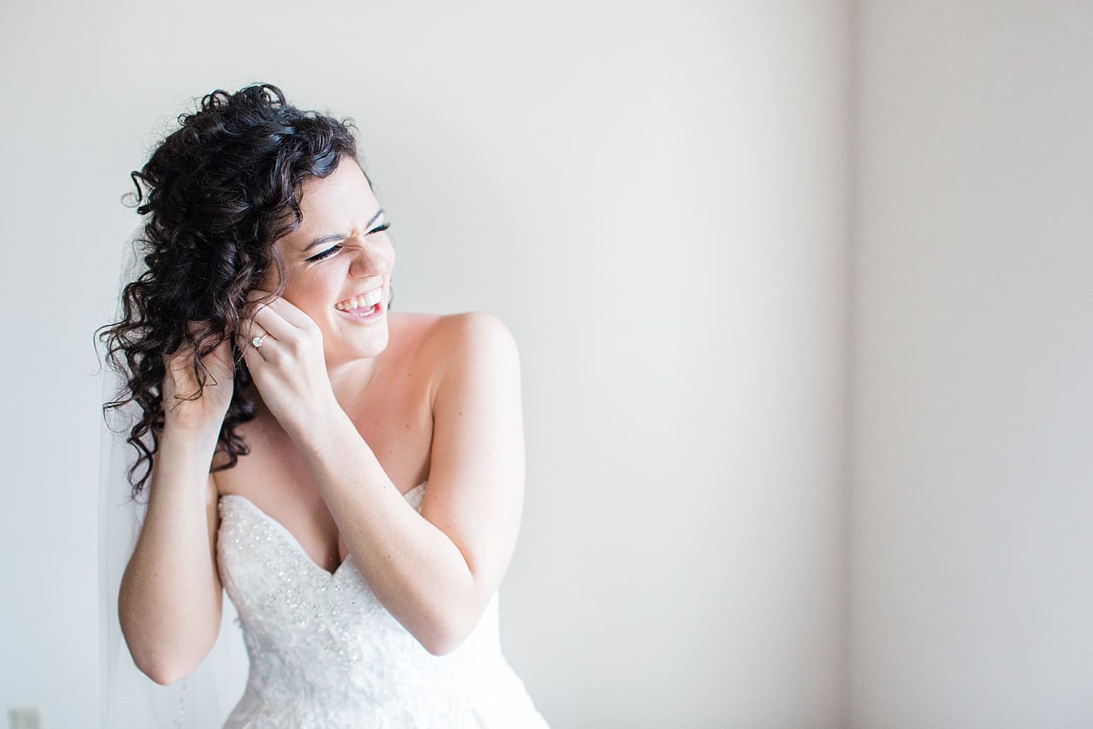 Arielle Peters Photography | Bride putting on earrings on wedding day at Baker Street Train Station in Fort Wayne, Indiana.