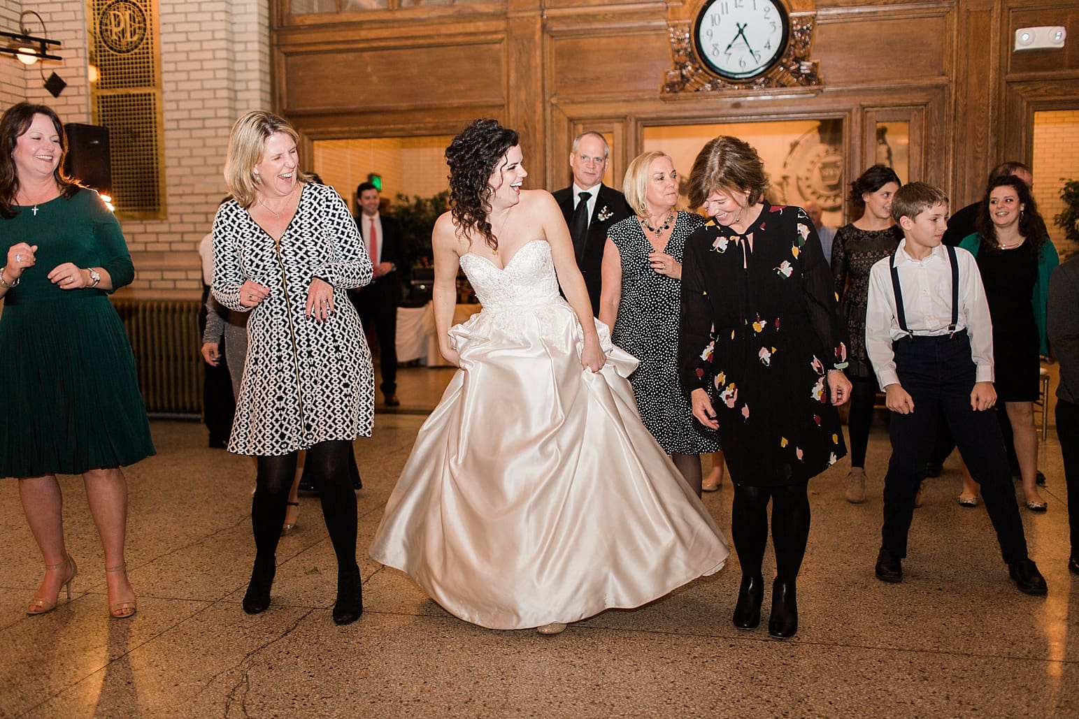 Arielle Peters Photography | Bride and groom dancing with guests at wedding reception at Baker Street Train Station in Fort Wayne, Indiana.