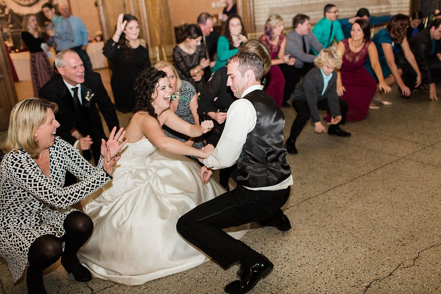 Arielle Peters Photography | Bride and groom dancing with guests at wedding reception at Baker Street Train Station in Fort Wayne, Indiana.