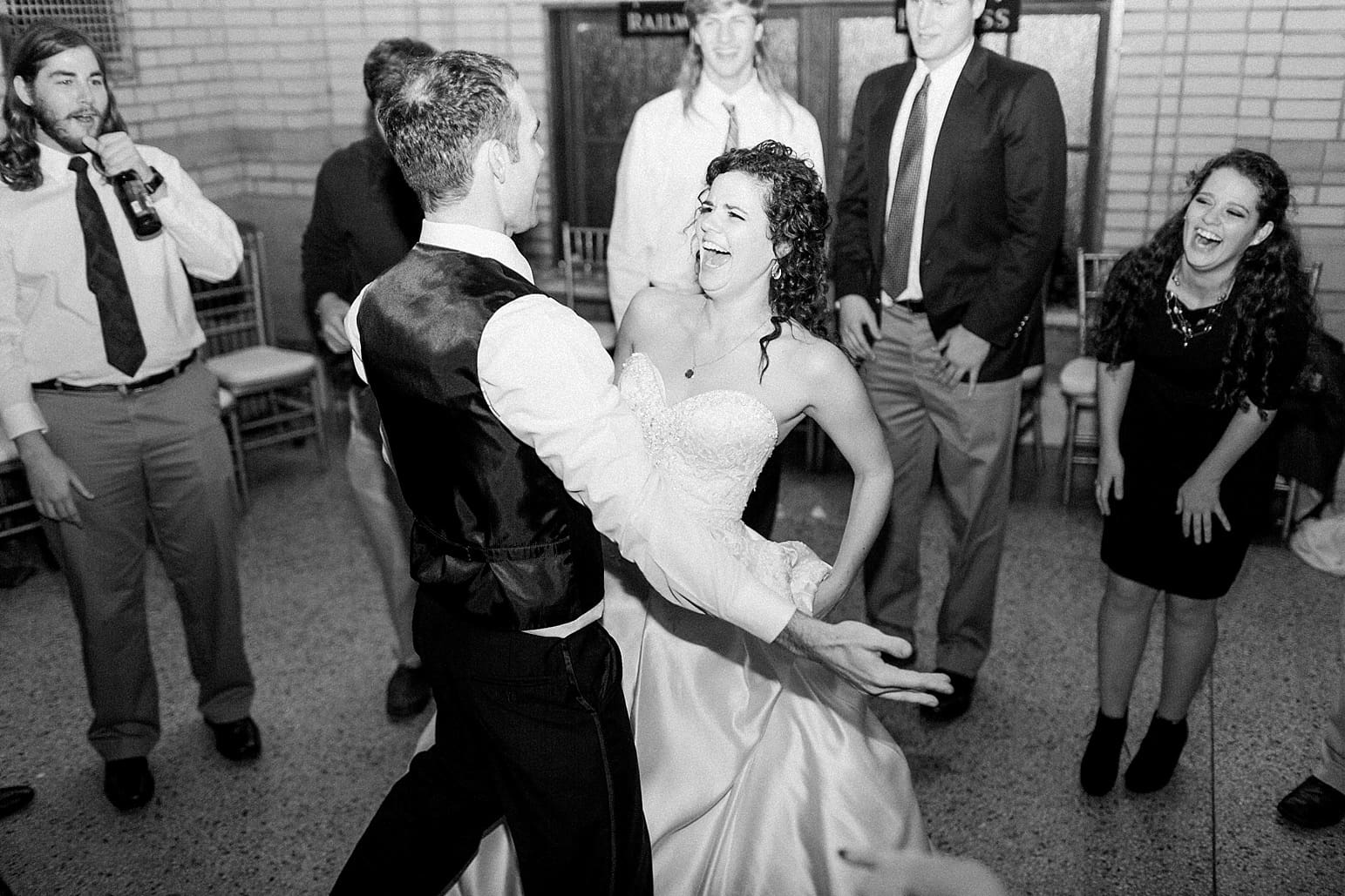 Arielle Peters Photography | Bride and groom laughing and dancing at wedding reception at Baker Street Train Station in Fort Wayne, Indiana.