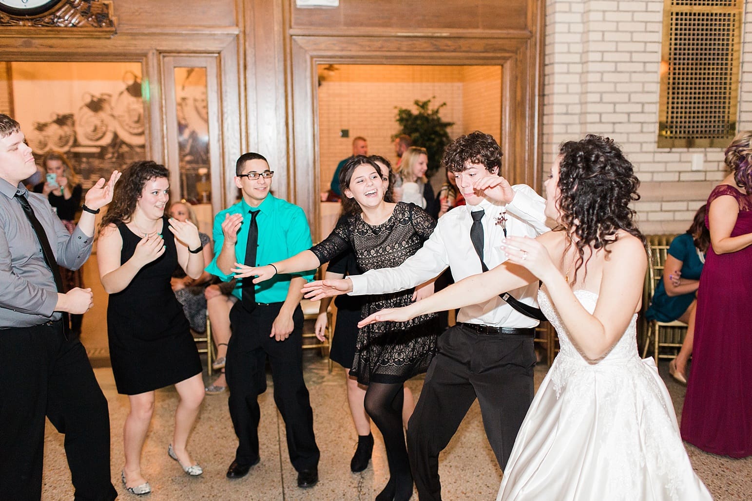 Arielle Peters Photography | Bride and groom dancing with guests at wedding reception at Baker Street Train Station in Fort Wayne, Indiana.