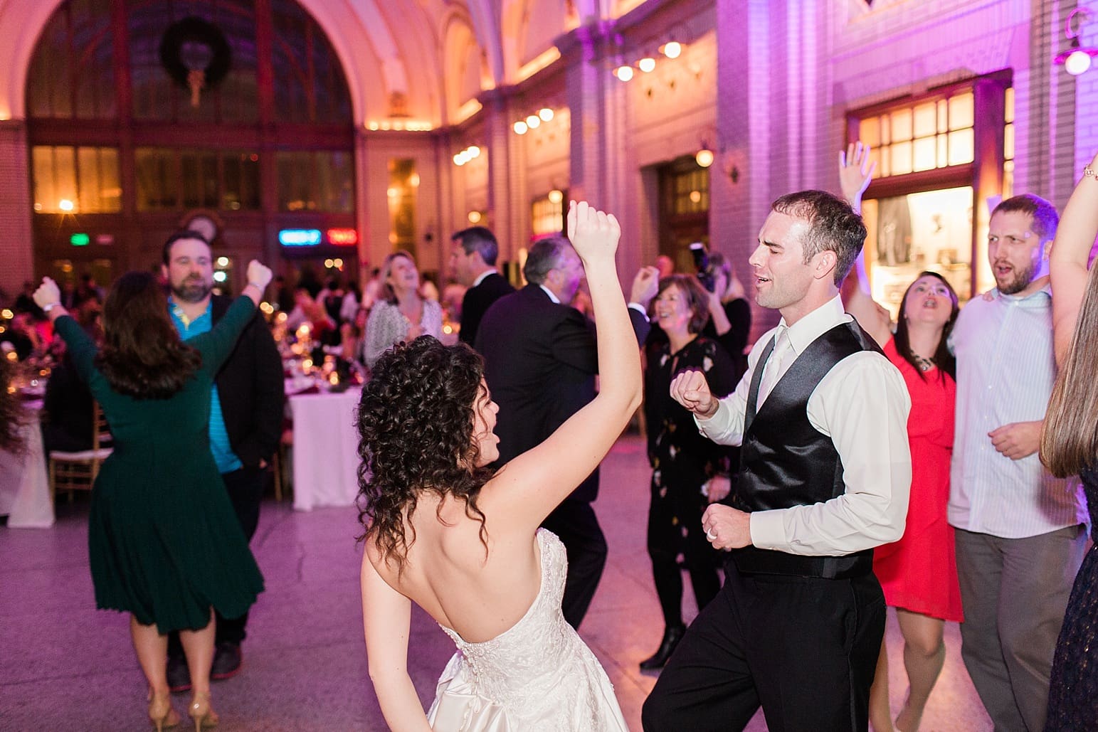 Arielle Peters Photography | Bride and groom dancing with guests at wedding reception at Baker Street Train Station in Fort Wayne, Indiana.