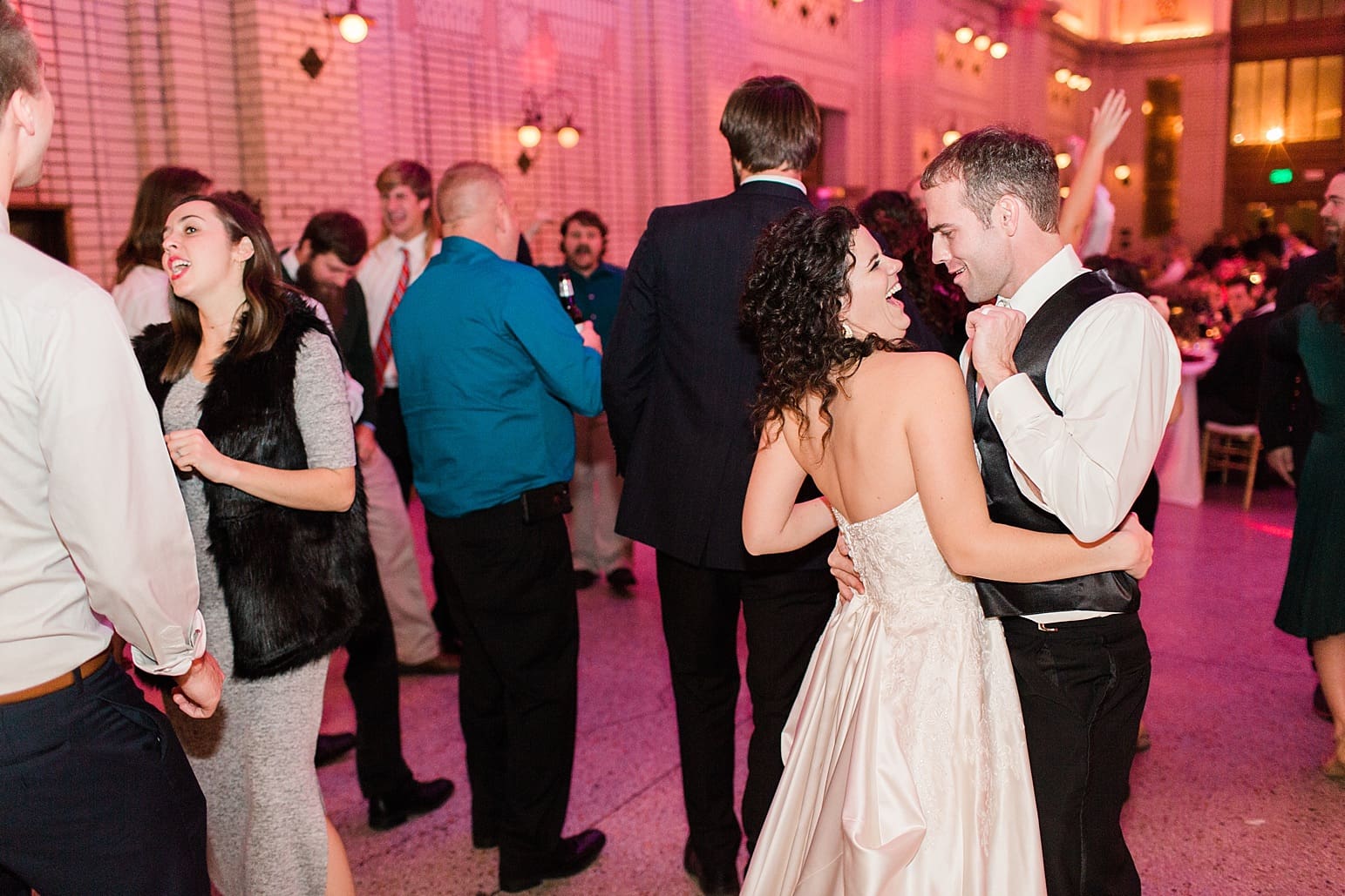 Arielle Peters Photography | Bride and groom dancing with guests at wedding reception at Baker Street Train Station in Fort Wayne, Indiana.