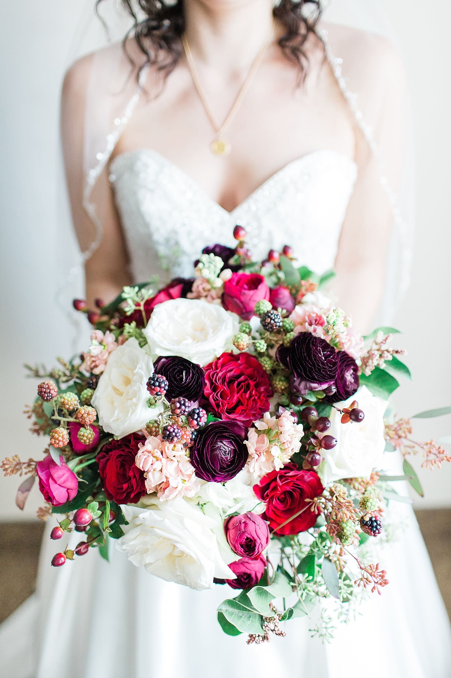 Arielle Peters Photography | Bride holding dark red floral bouquet on wedding day at Baker Street Train Station in Fort Wayne, Indiana.
