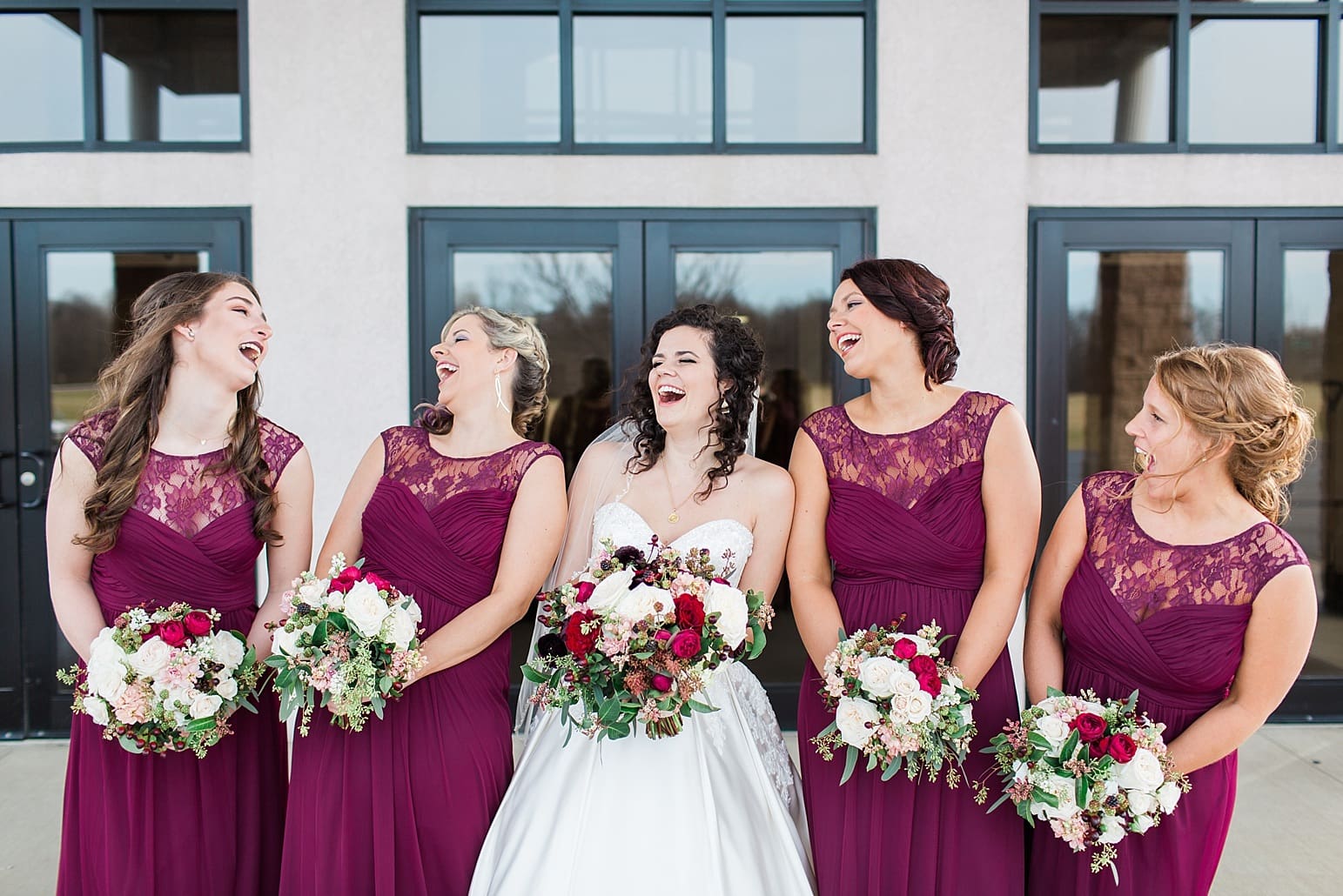 Arielle Peters Photography | Bride and bridesmaids laughing outside train station on wedding day at Baker Street Train Station in Fort Wayne, Indiana.