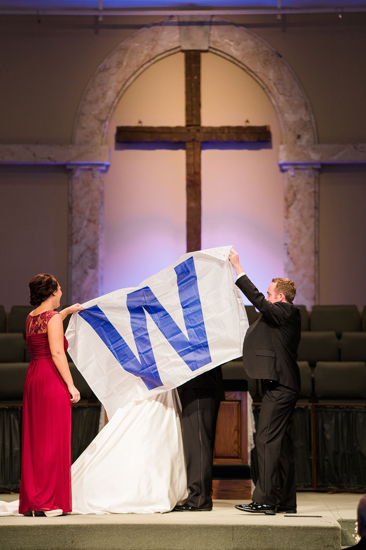 Arielle Peters Photography | Best man holding W flag at alter on wedding day at Baker Street Train Station in Fort Wayne, Indiana.