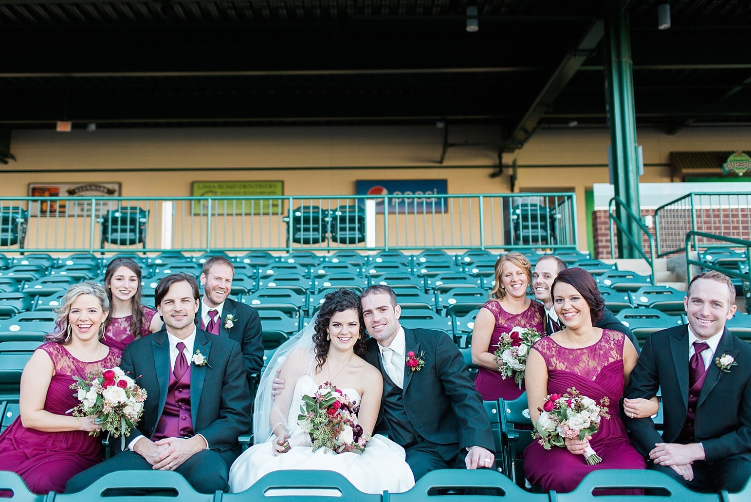 Arielle Peters Photography | Wedding party sitting on bleachers at Parkview Field on wedding day in Fort Wayne, Indiana.