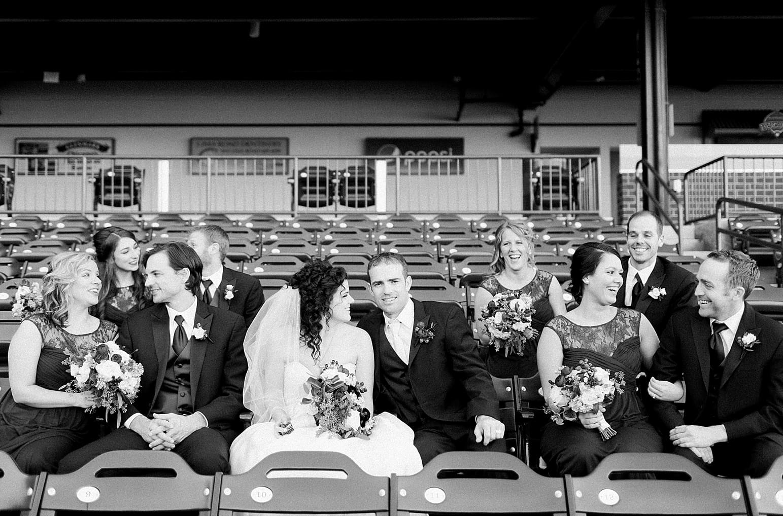Arielle Peters Photography | Wedding party sitting on bleachers at Parkview Field on wedding day in Fort Wayne, Indiana.