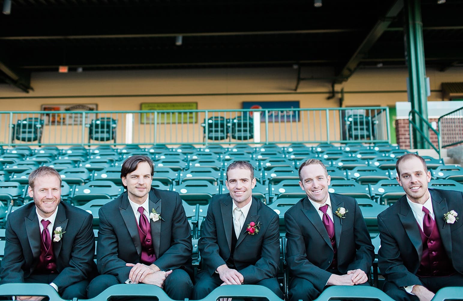 Arielle Peters Photography | Groom and groomsmen sitting on bleachers at Parkview Field on wedding day in Fort Wayne, Indiana.