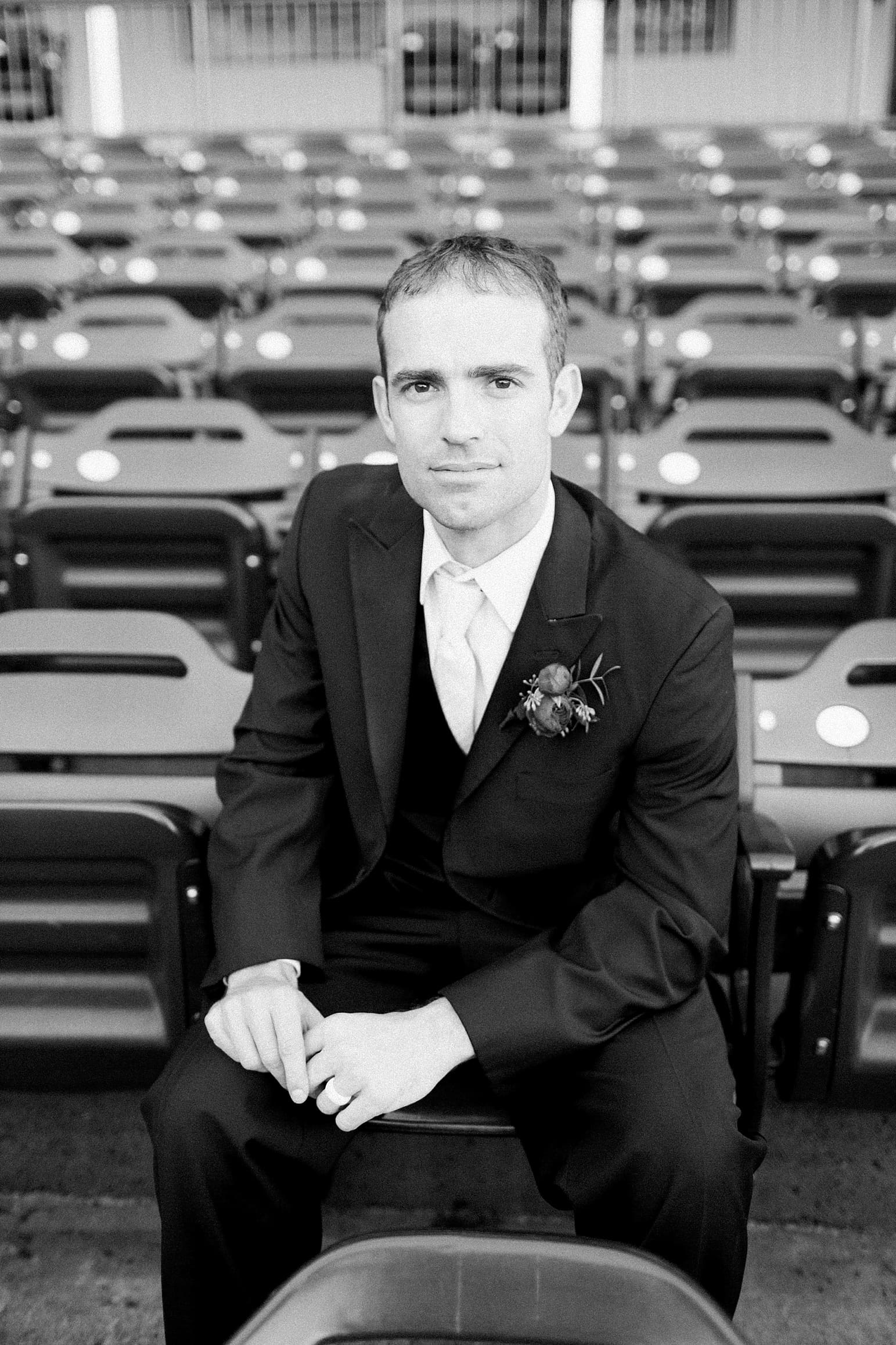 Arielle Peters Photography | Groom sitting on bleachers at Parkview Field on wedding day in Fort Wayne, Indiana.