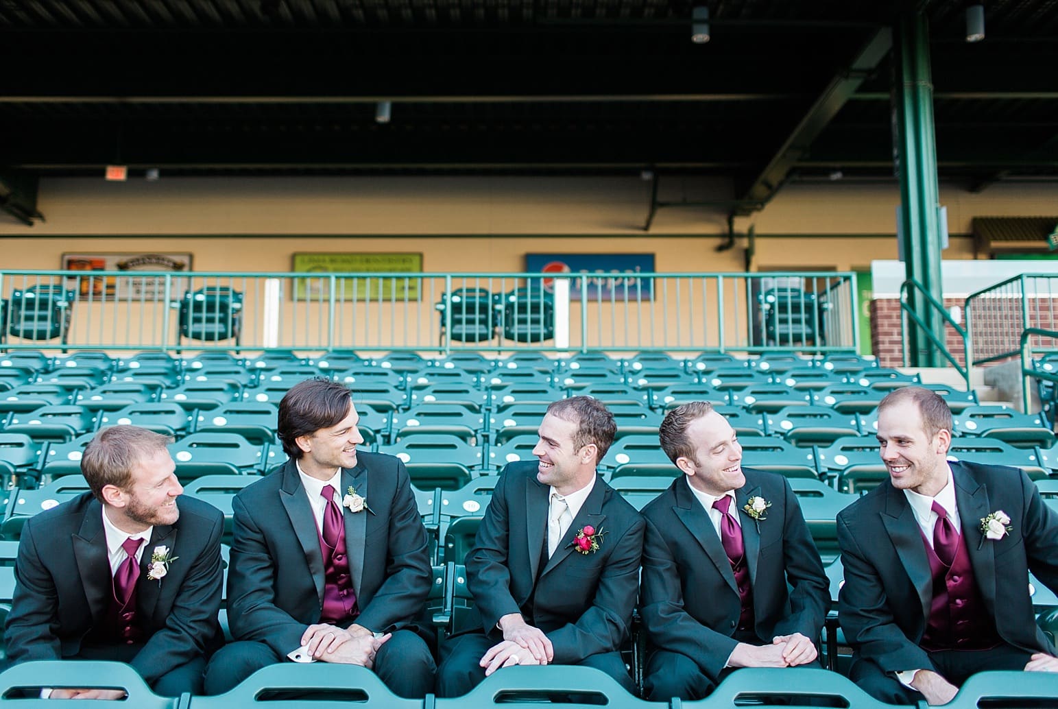Arielle Peters Photography | Groom and groomsmen sitting on bleachers at Parkview Field on wedding day in Fort Wayne, Indiana.