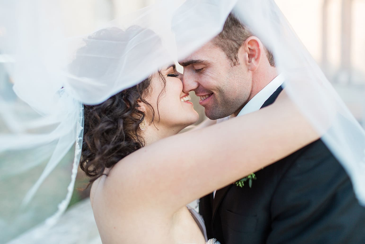 Arielle Peters Photography | Bride and groom almost kissing under bride's veil on wedding day at Baker Street Train Station in Fort Wayne, Indiana.
