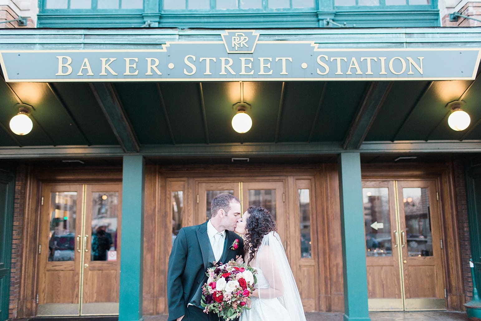 Arielle Peters Photography | Bride and groom on wedding day kissing outside Baker Street Train Station in Fort Wayne, Indiana.