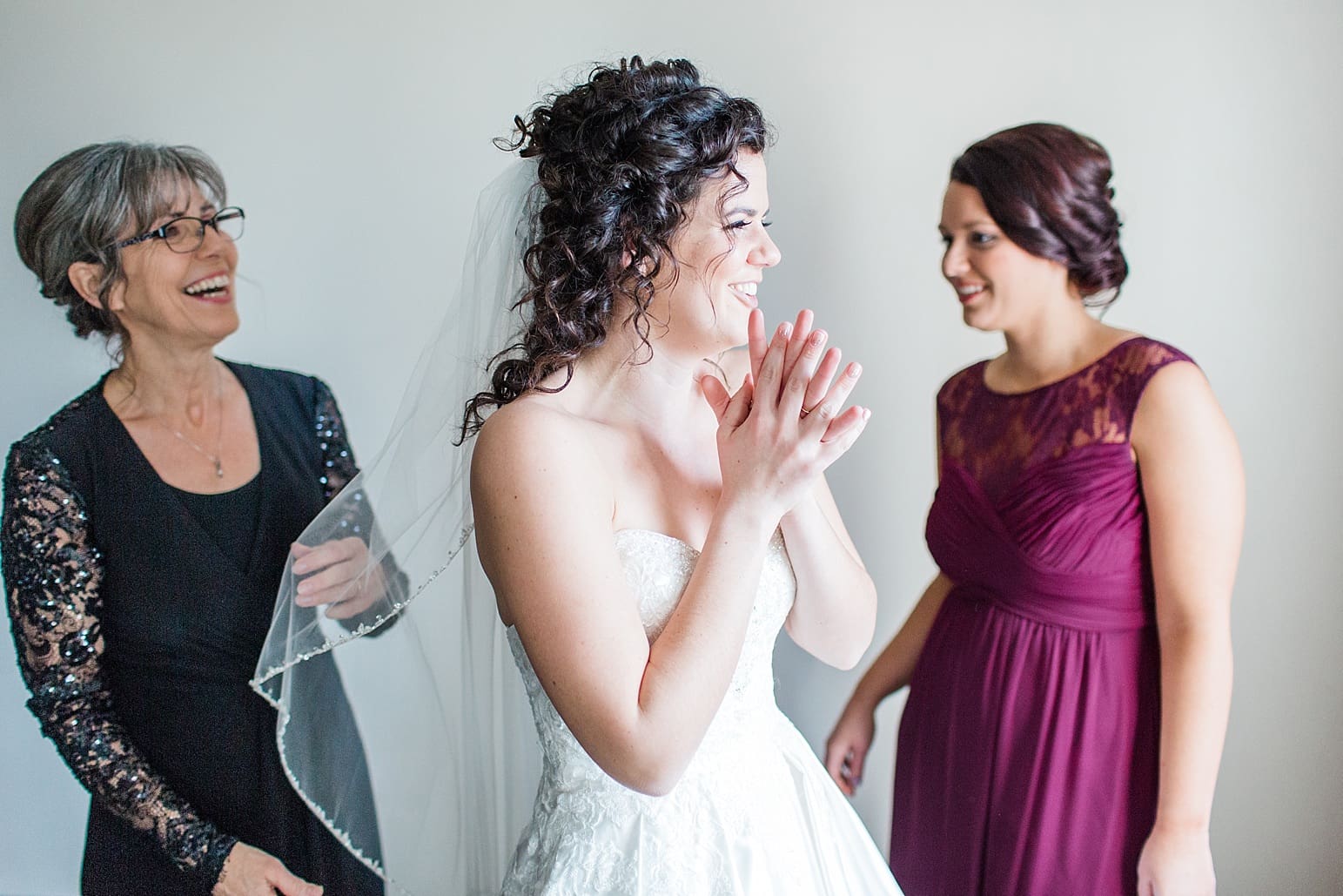 Arielle Peters Photography | Mother of bride helping bride put on dress on wedding day at Baker Street Train Station in Fort Wayne, Indiana.