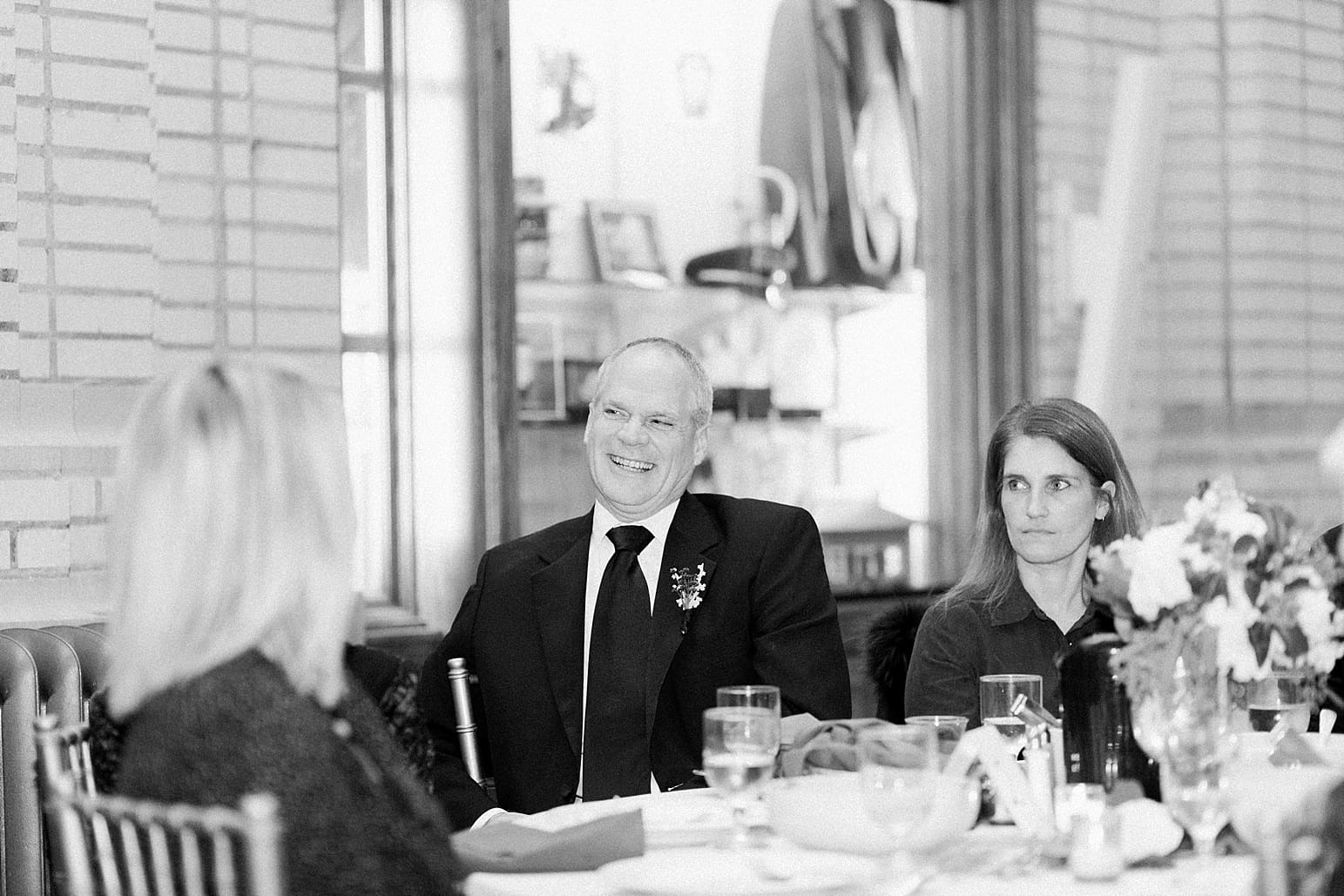 Arielle Peters Photography | Wedding guests laughing during toasts at wedding reception at Baker Street Train Station in Fort Wayne, Indiana.