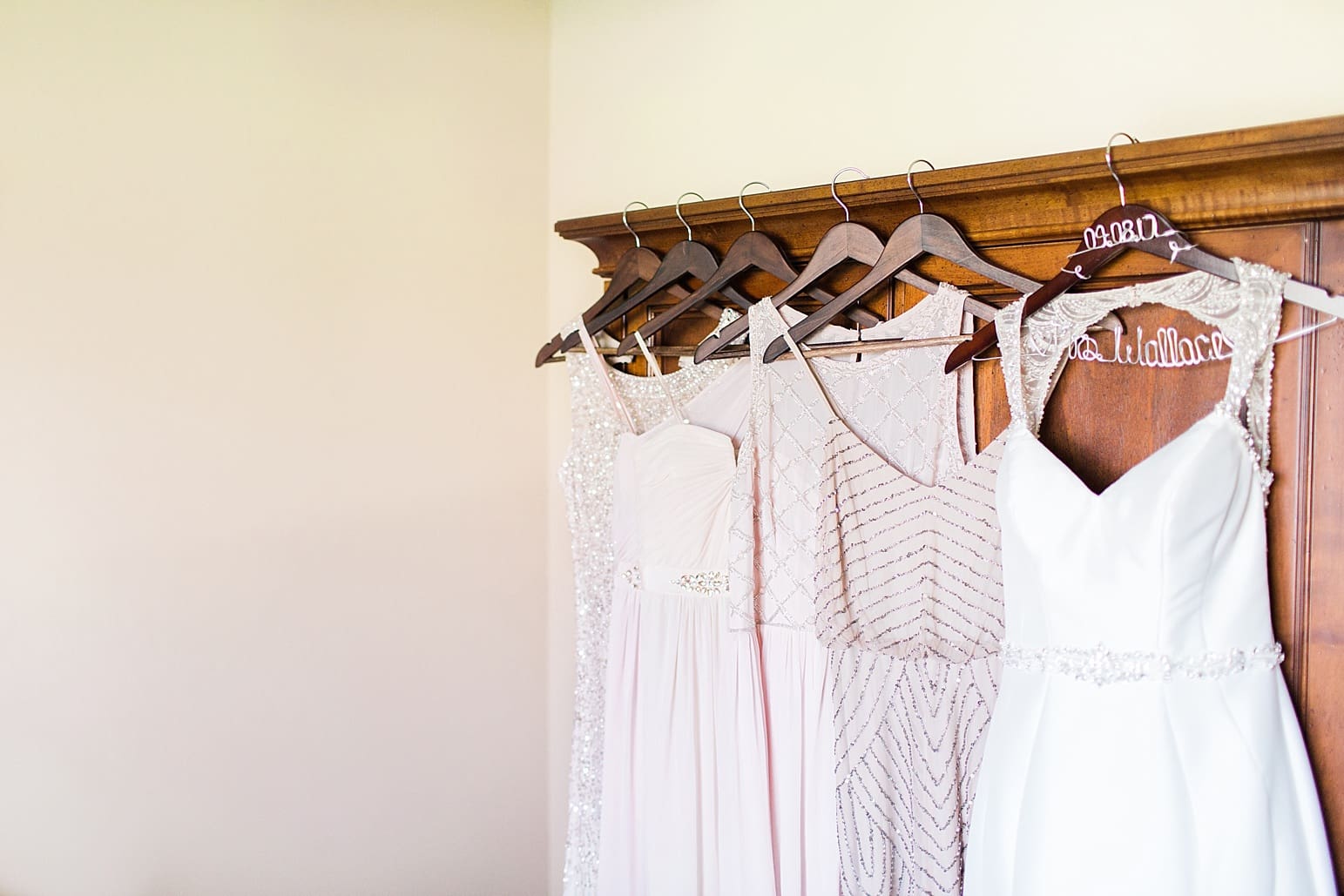 Arielle Peters Photography | Wedding dress and bridesmaids dresses hanging on wooden armoire on wedding day at The Market in Valparaiso, Indiana.