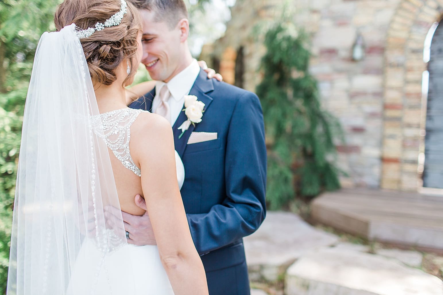 Arielle Peters Photography | Groom holding bride's back on next to historic brick wall on wedding day at The Market in Valparaiso, Indiana.