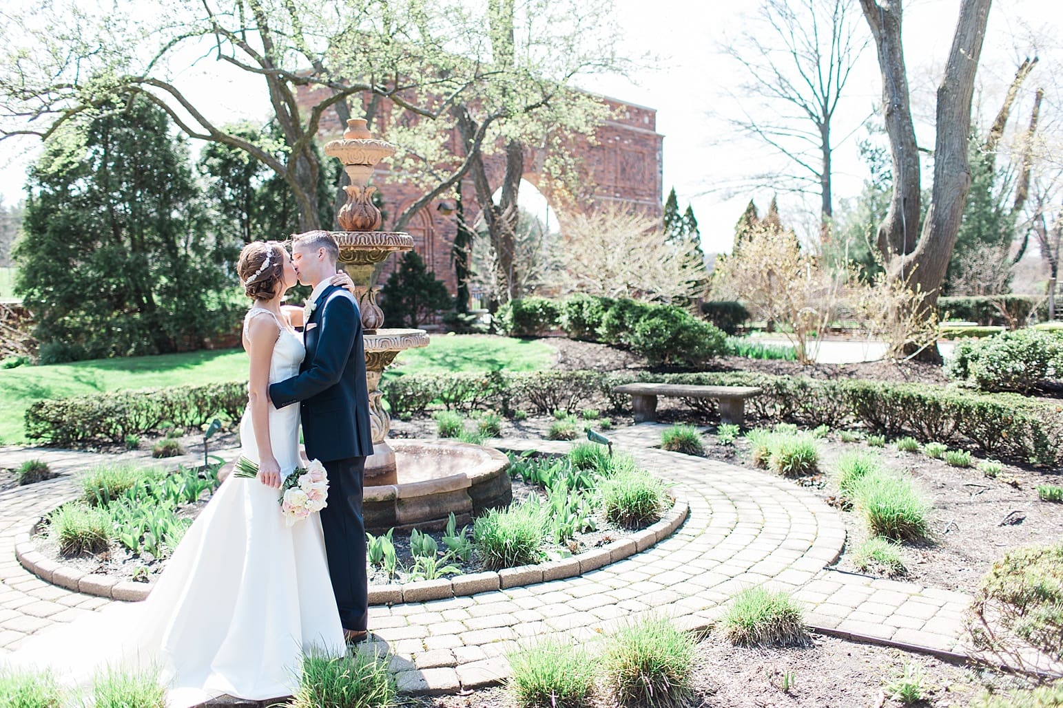 Arielle Peters Photography | Bride and groom kissing next to old fountain courtyard on wedding day at The Market in Valparaiso, Indiana.
