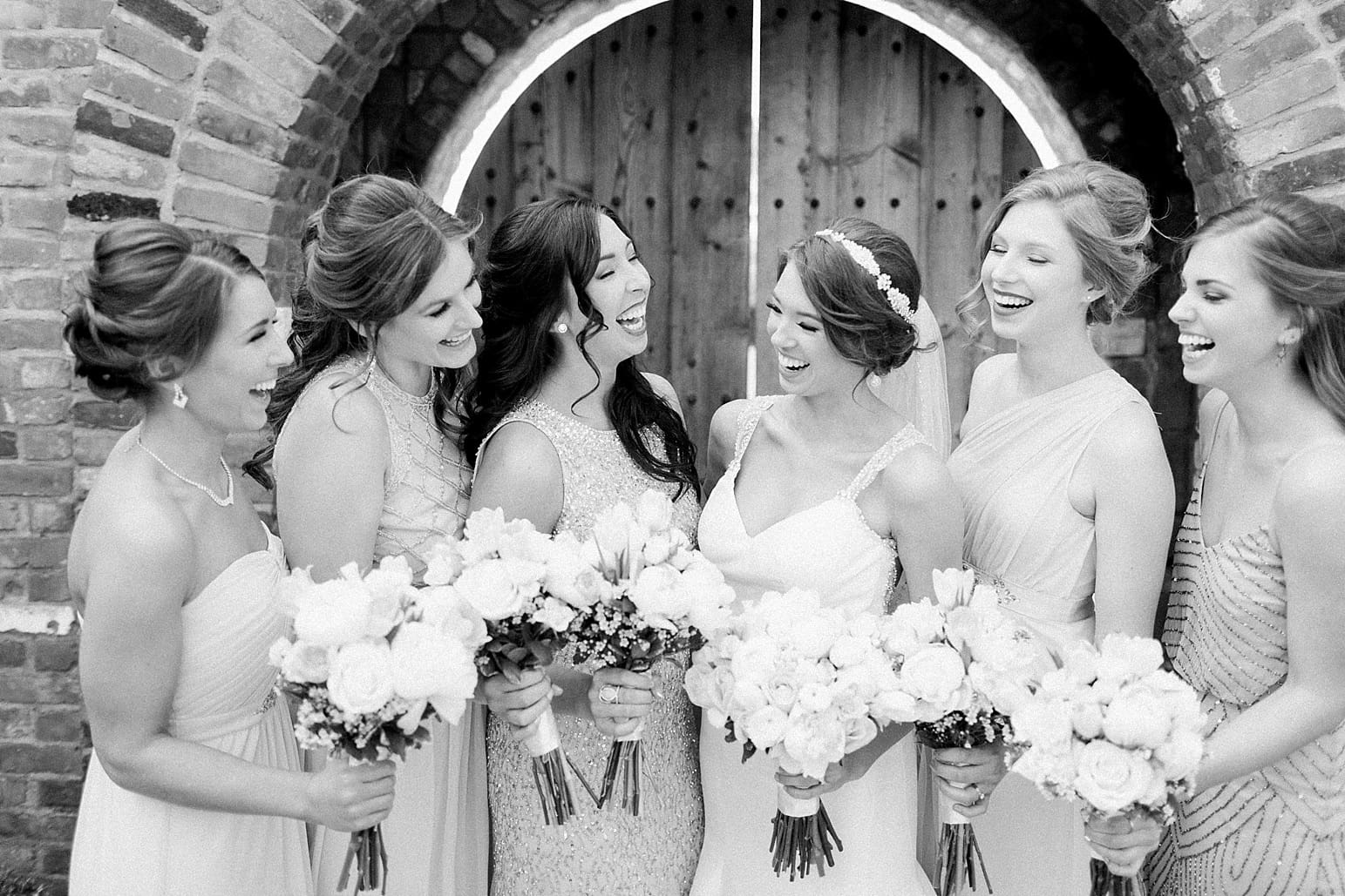 Arielle Peters Photography | Bride and bridesmaids in front of old brick archway on wedding day at The Market in Valparaiso, Indiana.