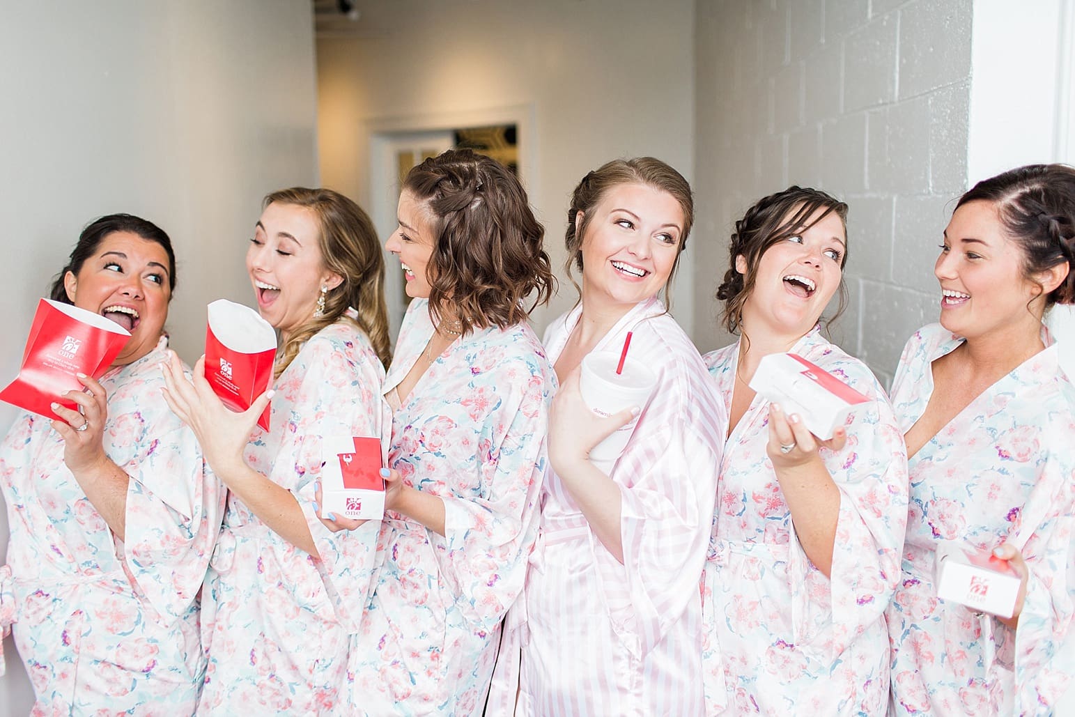 Arielle Peters Photography | Bride and bridesmaids in robes eating Chick-fil-A on wedding day at Loft 310 in Kalamazoo, Michigan.