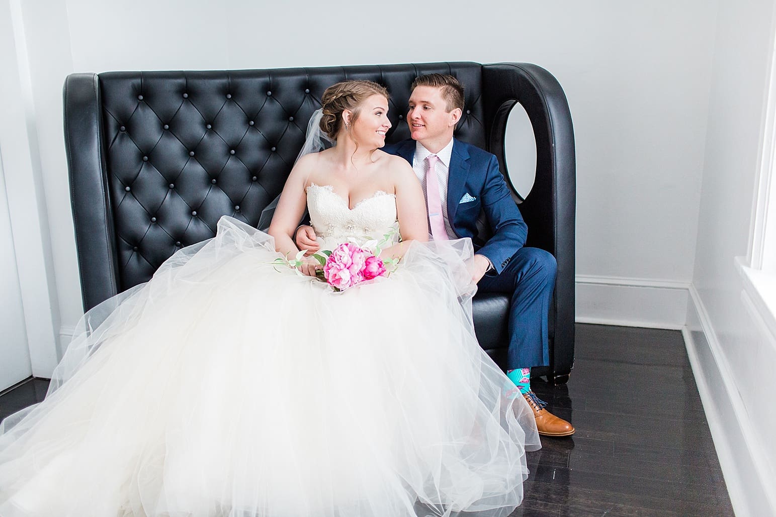 Arielle Peters Photography | Bride and groom sitting on leather couch on wedding day at Loft 310 in Kalamazoo, Michigan.