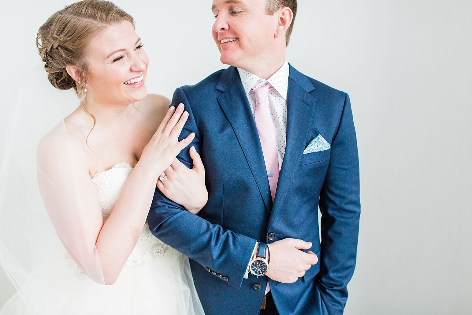 Arielle Peters Photography | Bride and groom next to white wall on wedding day at Loft 310 in Kalamazoo, Michigan.