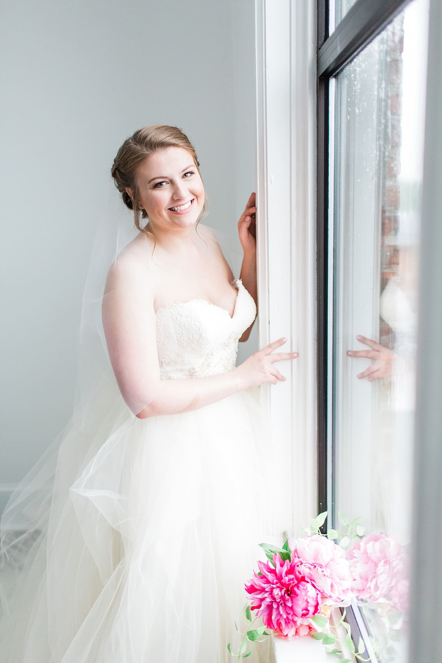 Arielle Peters Photography | Bride next to large loft window on wedding day at Loft 310 in Kalamazoo, Michigan.