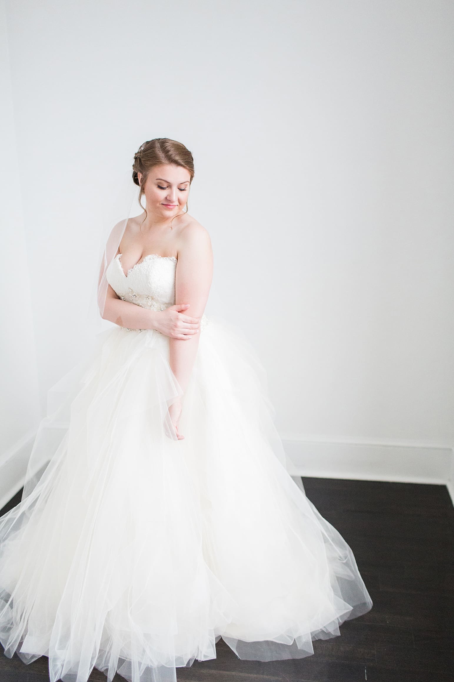 Arielle Peters Photography | Bride next to white walls on wedding day at Loft 310 in Kalamazoo, Michigan.