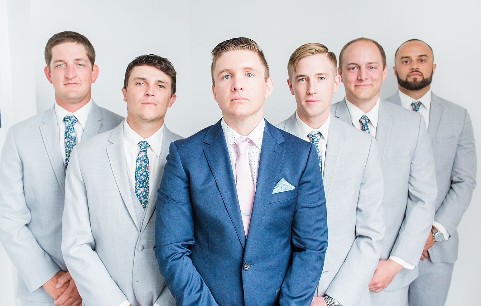 Arielle Peters Photography | Groom and groomsmen next to white walls on wedding day at Loft 310 in Kalamazoo, Michigan.