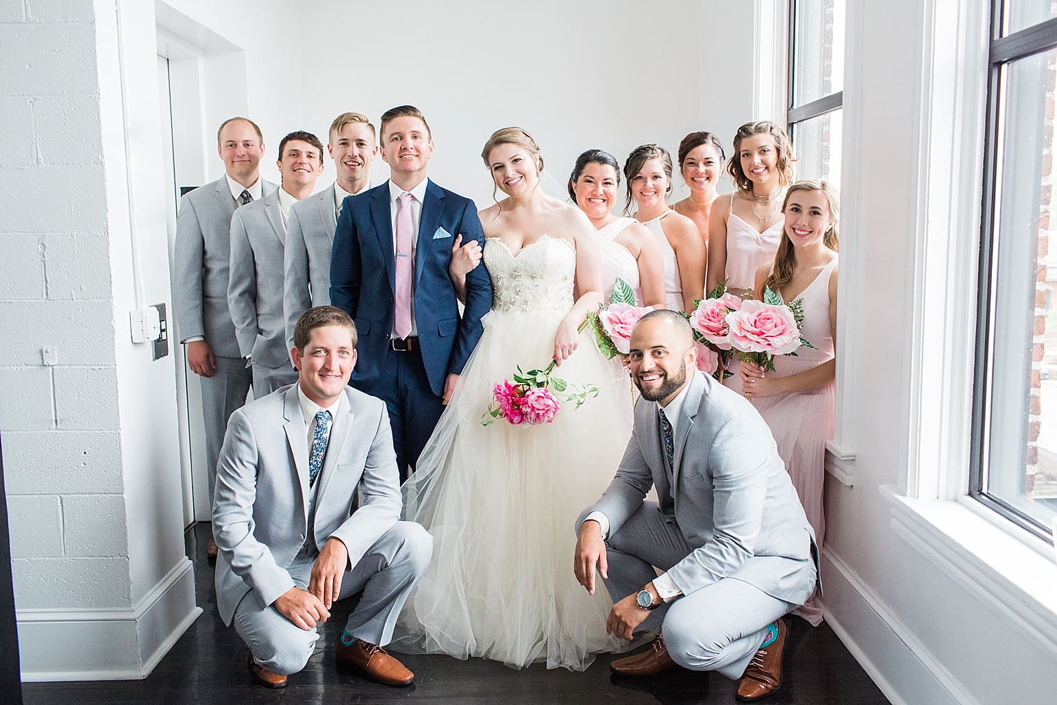 Arielle Peters Photography | Wedding party next to large loft window on wedding day at Loft 310 in Kalamazoo, Michigan.