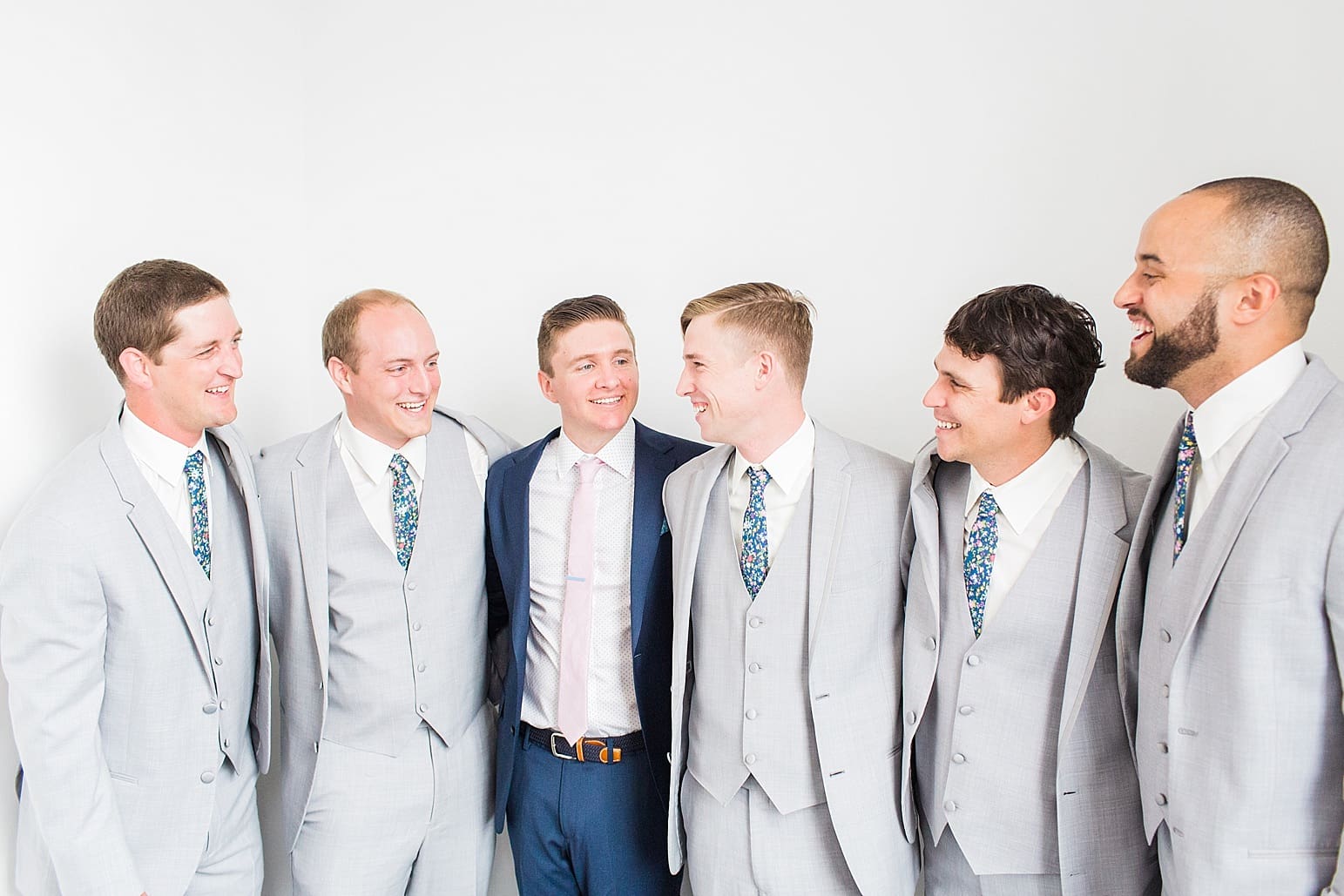 Arielle Peters Photography | Groom and groomsmen next to white walls on wedding day at Loft 310 in Kalamazoo, Michigan.