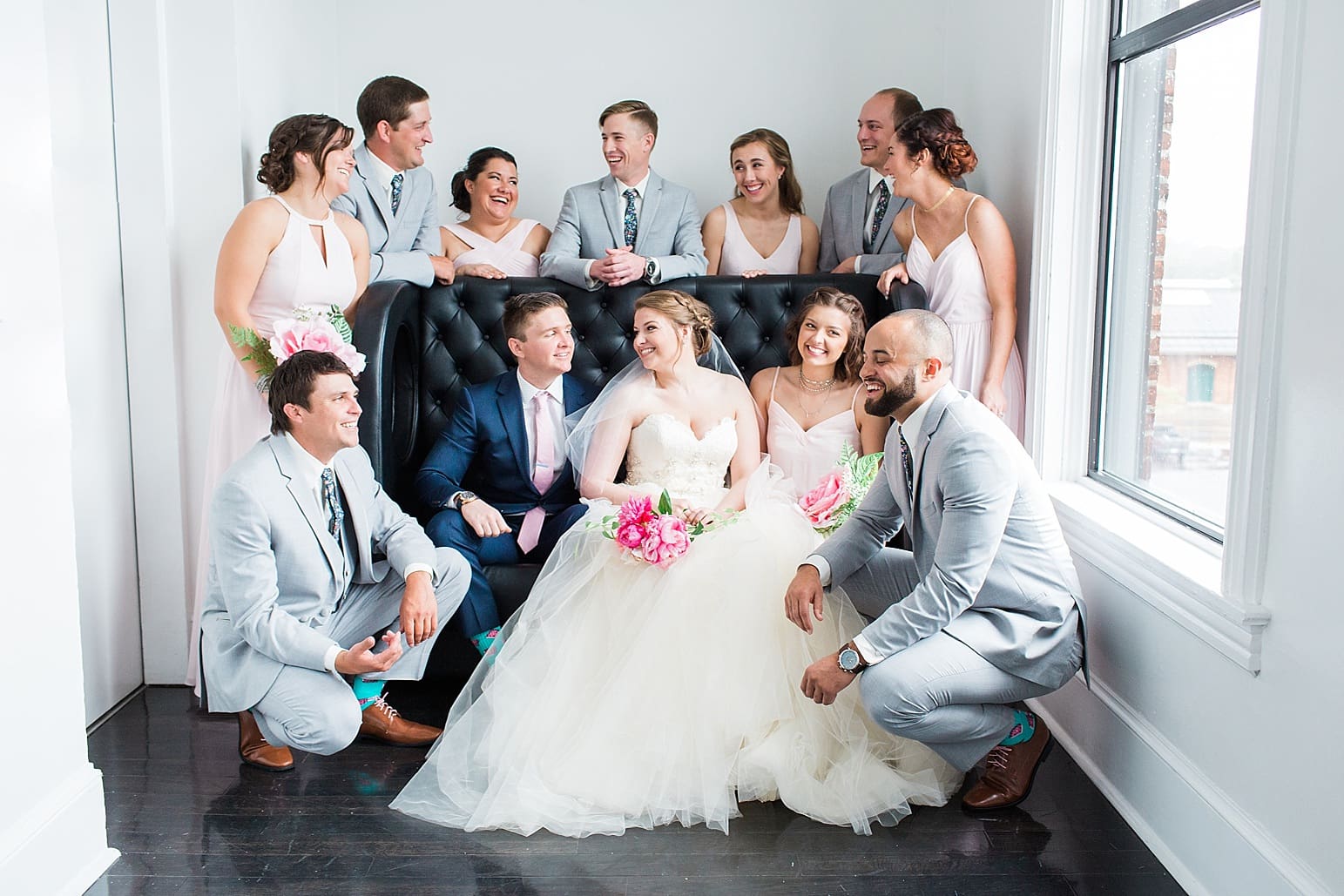 Arielle Peters Photography | Wedding party next to large loft window on wedding day at Loft 310 in Kalamazoo, Michigan.