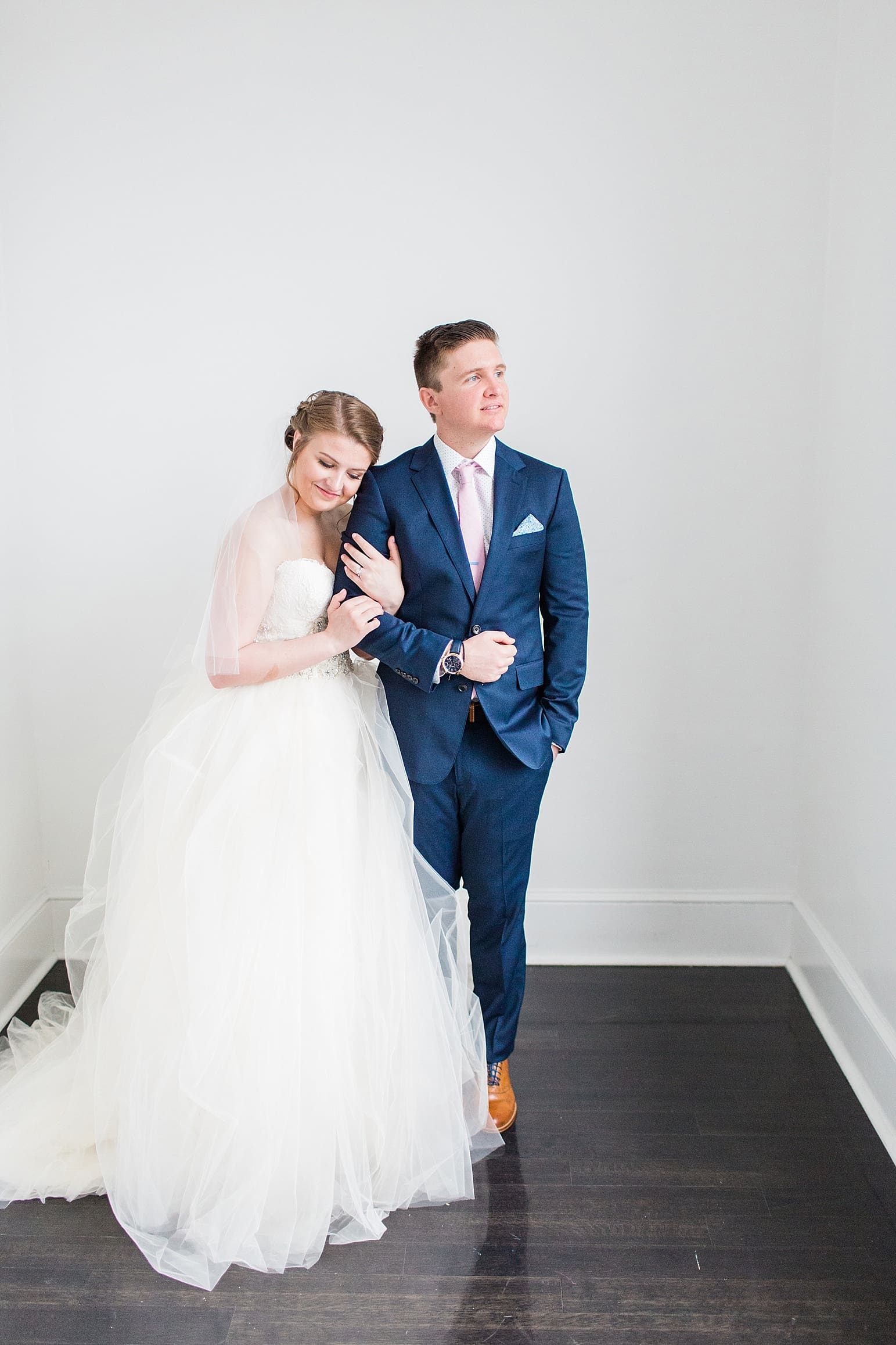 Arielle Peters Photography | Bride and groom next to large loft window on wedding day at Loft 310 in Kalamazoo, Michigan.