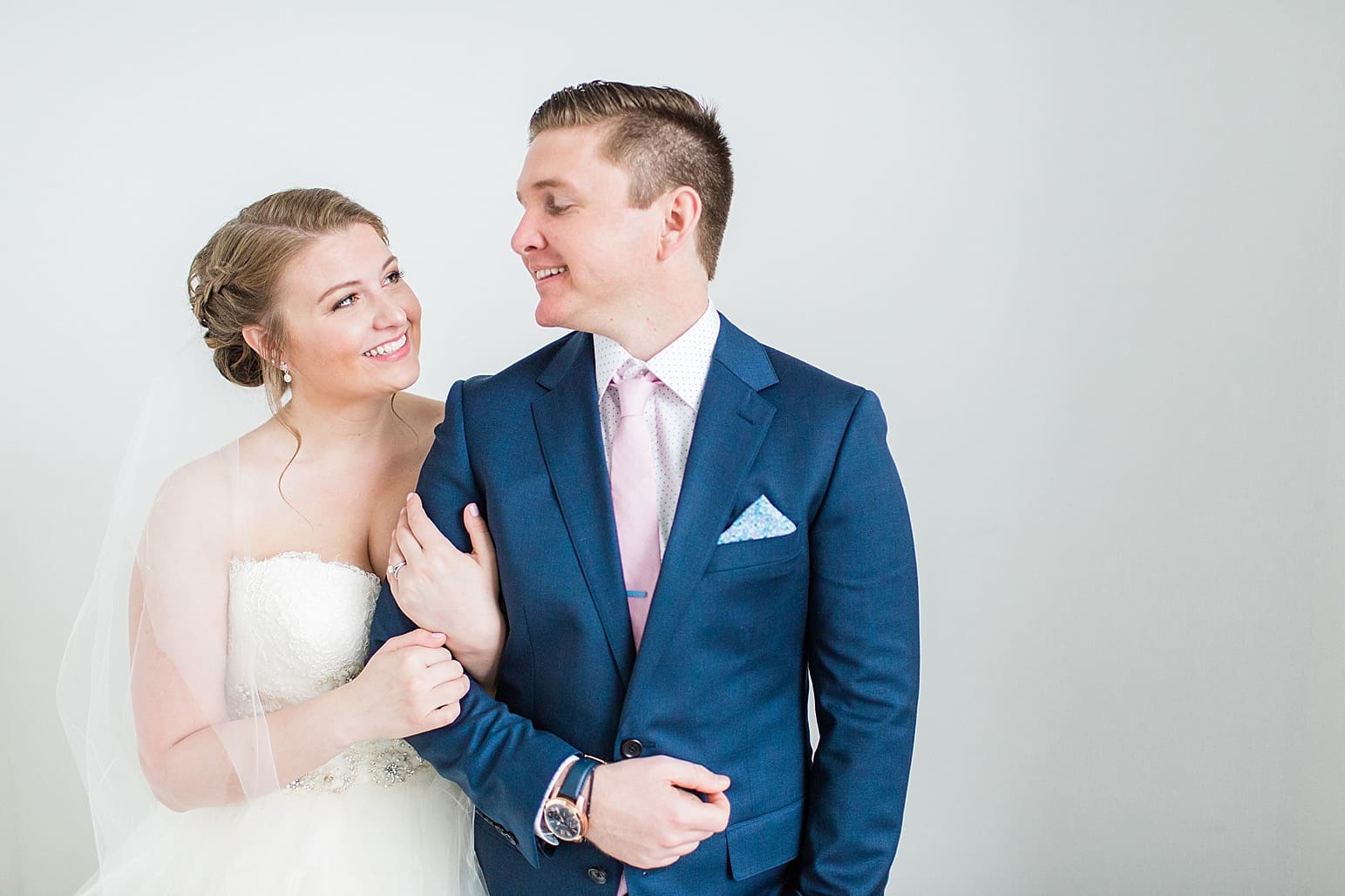 Arielle Peters Photography | Bride and groom next to white walls on wedding day at Loft 310 in Kalamazoo, Michigan.