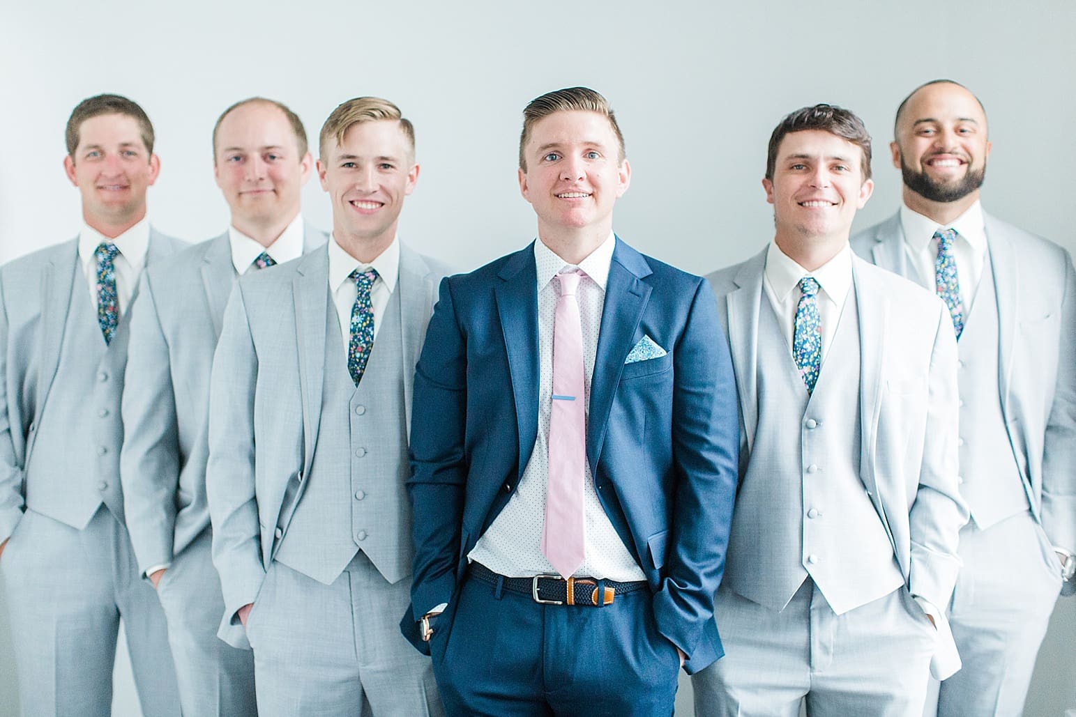 Arielle Peters Photography | Groom and groomsmen next to white walls on wedding day at Loft 310 in Kalamazoo, Michigan.