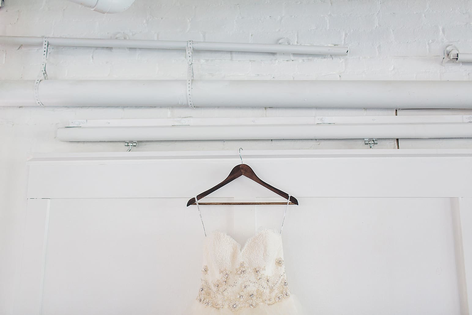 Arielle Peters Photography | Wedding dress hanging on loft doors on wedding day at Loft 310 in Kalamazoo, Michigan.