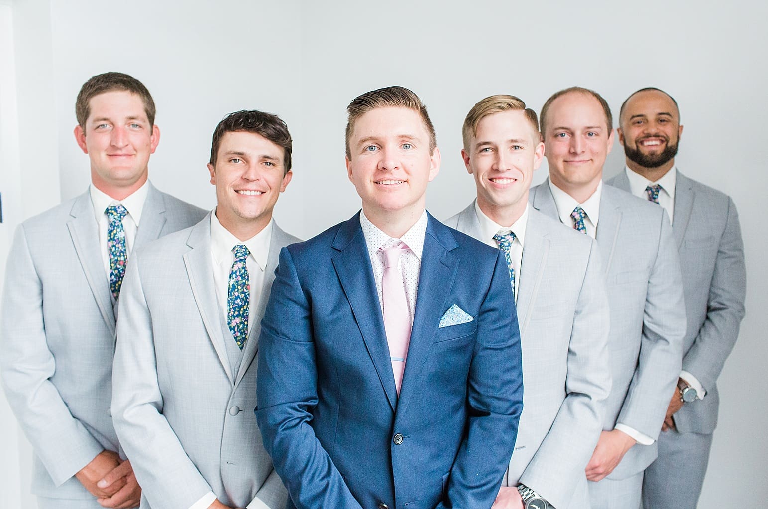 Arielle Peters Photography | Groom and groomsmen next to white walls on wedding day at Loft 310 in Kalamazoo, Michigan.