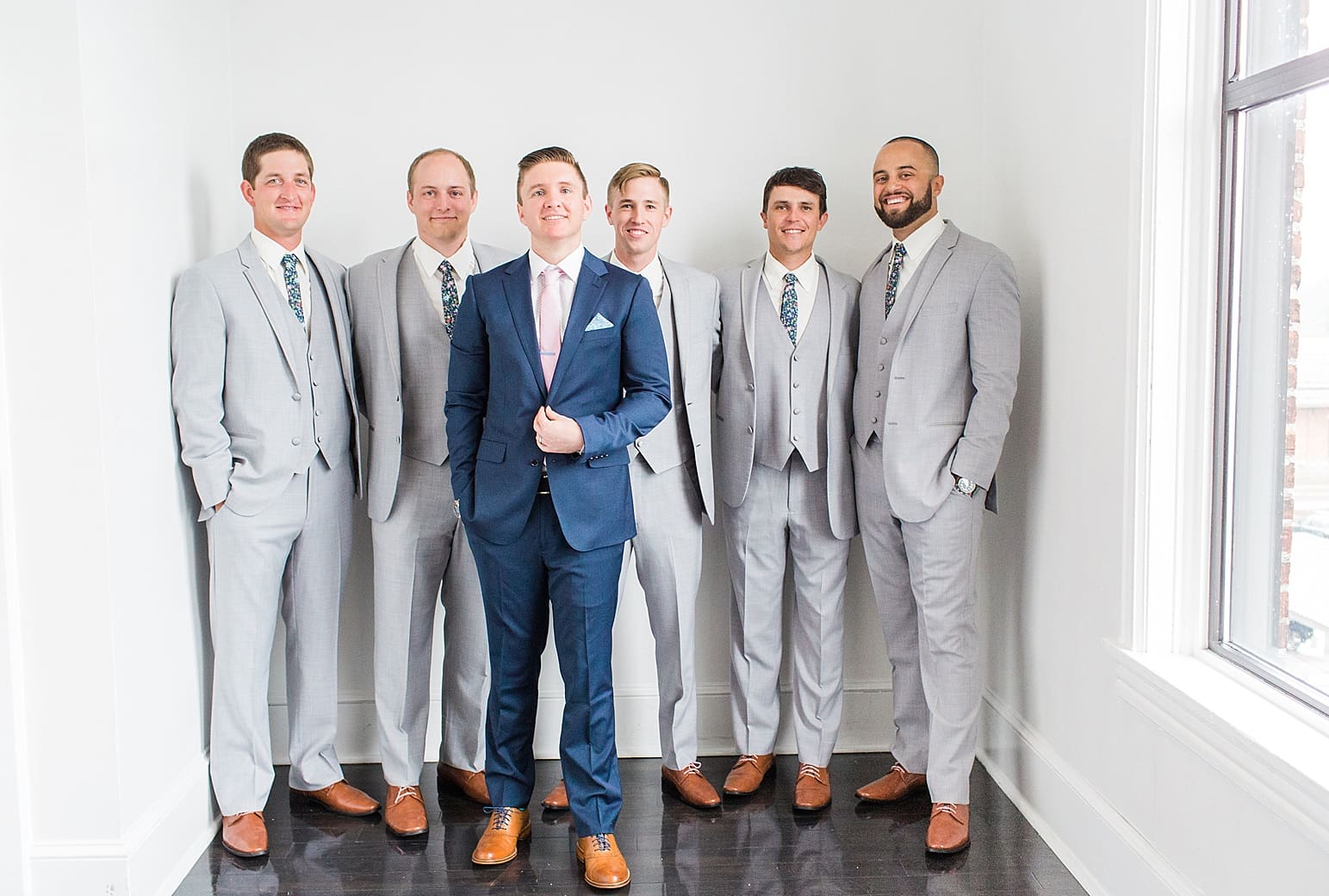 Arielle Peters Photography | Groom and groomsmen next to white walls on wedding day at Loft 310 in Kalamazoo, Michigan.