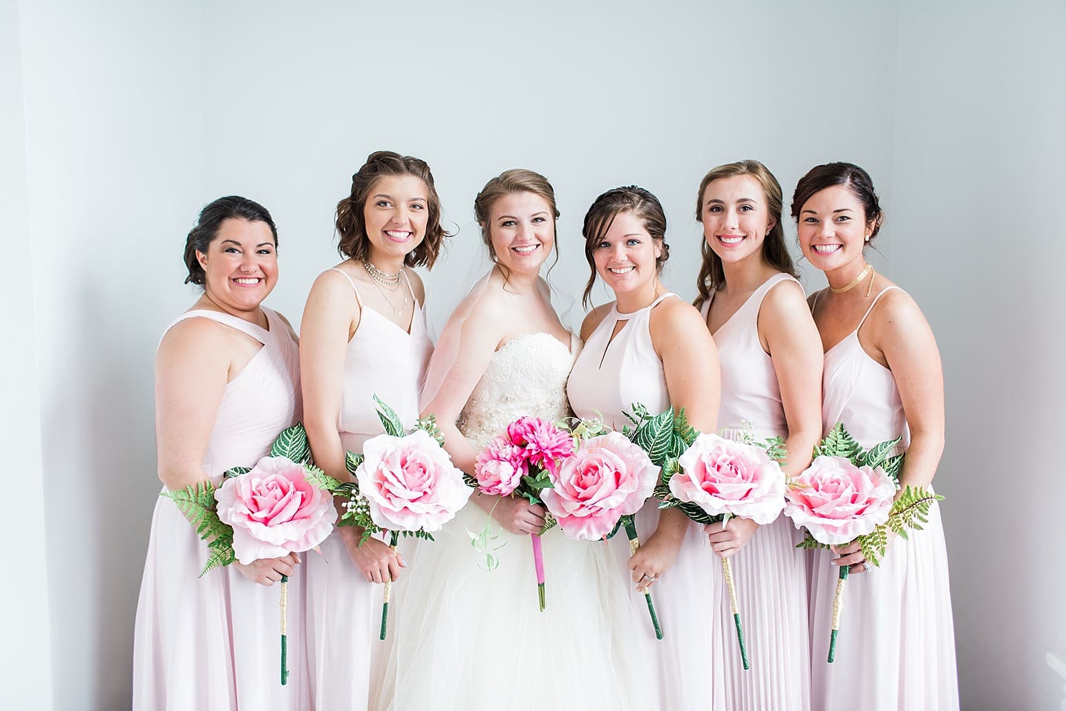 Arielle Peters Photography | Bride and bridesmaids next to white walls on wedding day at Loft 310 in Kalamazoo, Michigan.