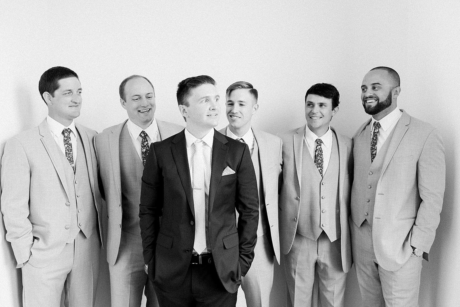 Arielle Peters Photography | Groom and groomsmen next to white walls on wedding day at Loft 310 in Kalamazoo, Michigan.