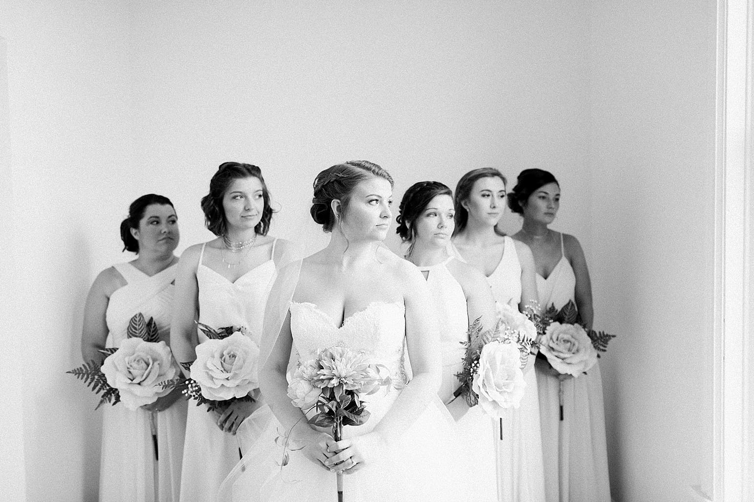 Arielle Peters Photography | Bride and bridesmaids looking out large loft windows on wedding day at Loft 310 in Kalamazoo, Michigan.