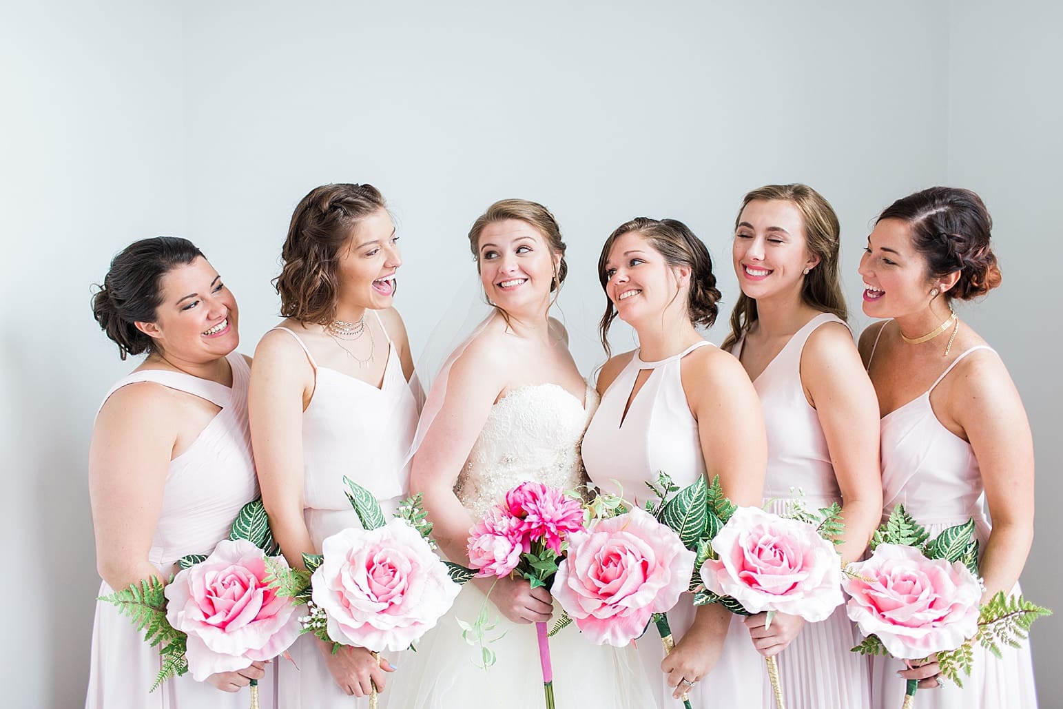 Arielle Peters Photography | Bride and bridesmaids next to white walls on wedding day at Loft 310 in Kalamazoo, Michigan.