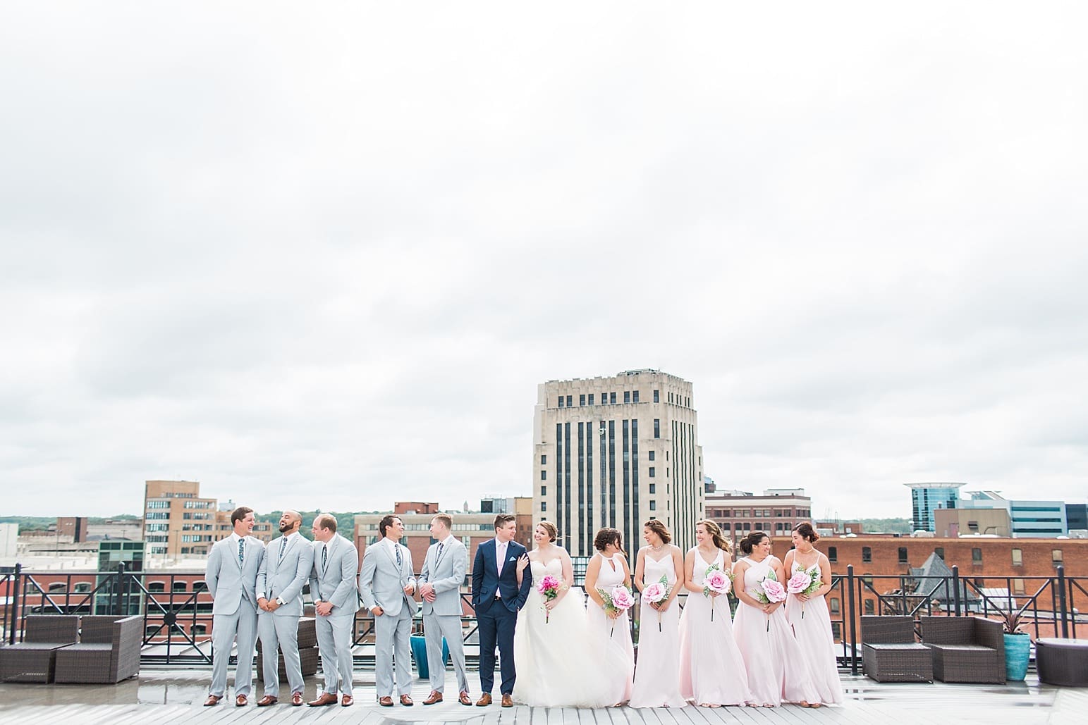 Arielle Peters Photography | Wedding party standing on rooftop terrace overlooking the city on wedding day at Loft 310 in Kalamazoo, Michigan.