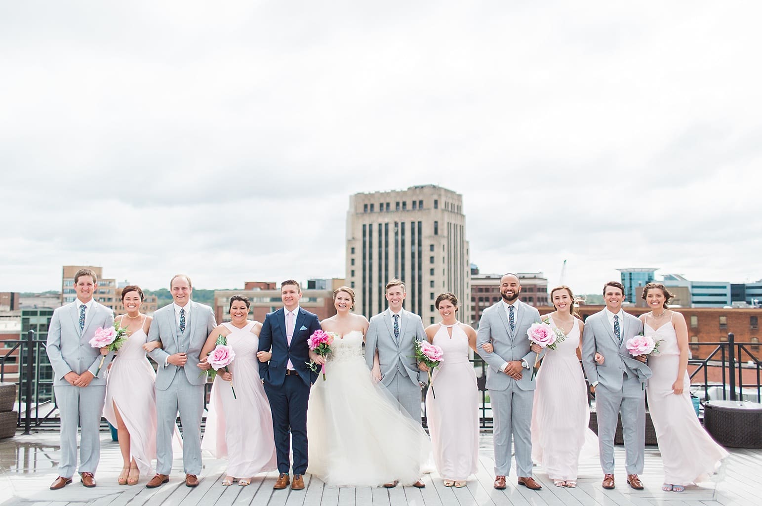 Arielle Peters Photography | Wedding party standing on rooftop terrace overlooking the city on wedding day at Loft 310 in Kalamazoo, Michigan.