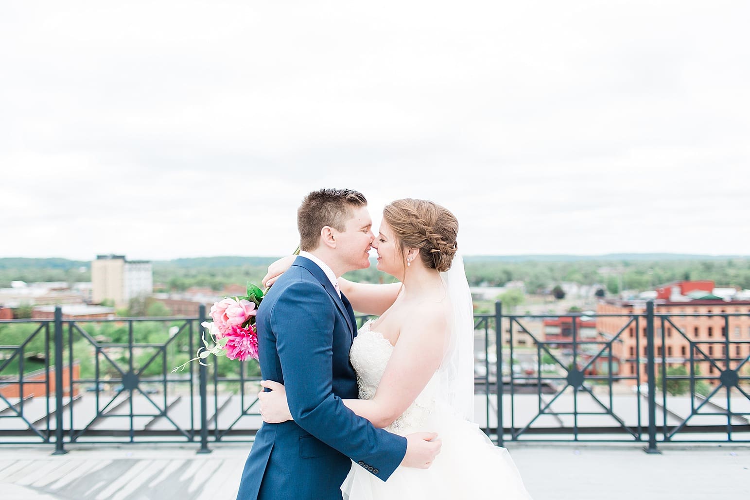 Arielle Peters Photography | Bride and groom almost kissing on rooftop terrace overlooking the city on wedding day at Loft 310 in Kalamazoo, Michigan.