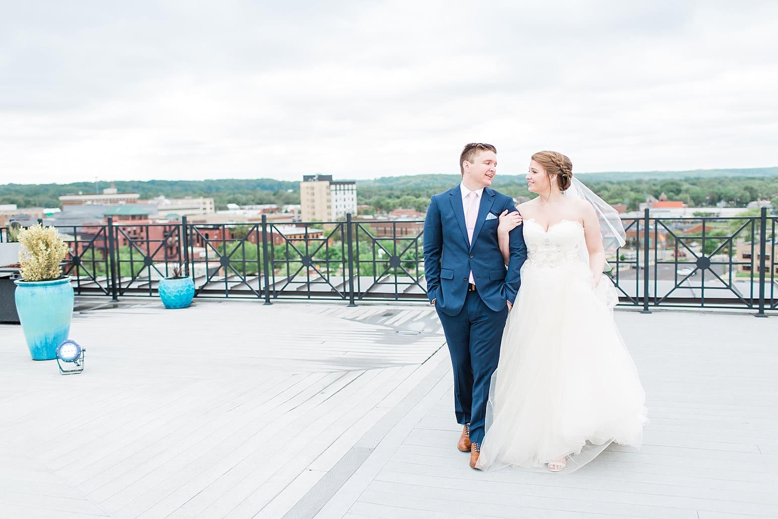 Arielle Peters Photography | Bride and groom walking on rooftop terrace overlooking the city on wedding day at Loft 310 in Kalamazoo, Michigan.