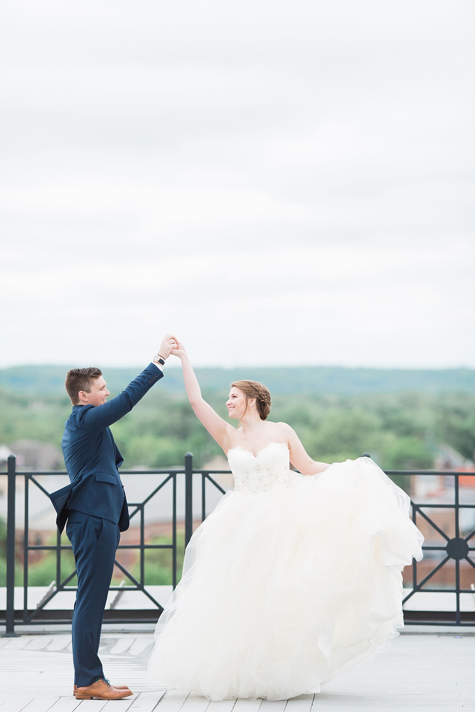 Arielle Peters Photography | Bride and groom dancing on rooftop terrace overlooking the city on wedding day at Loft 310 in Kalamazoo, Michigan.