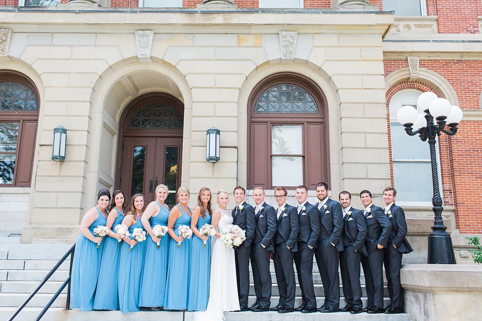 Arielle Peters Photography | Bride and groom next to limestone church on wedding day at the Spohn Ballroom in Goshen, Indiana.