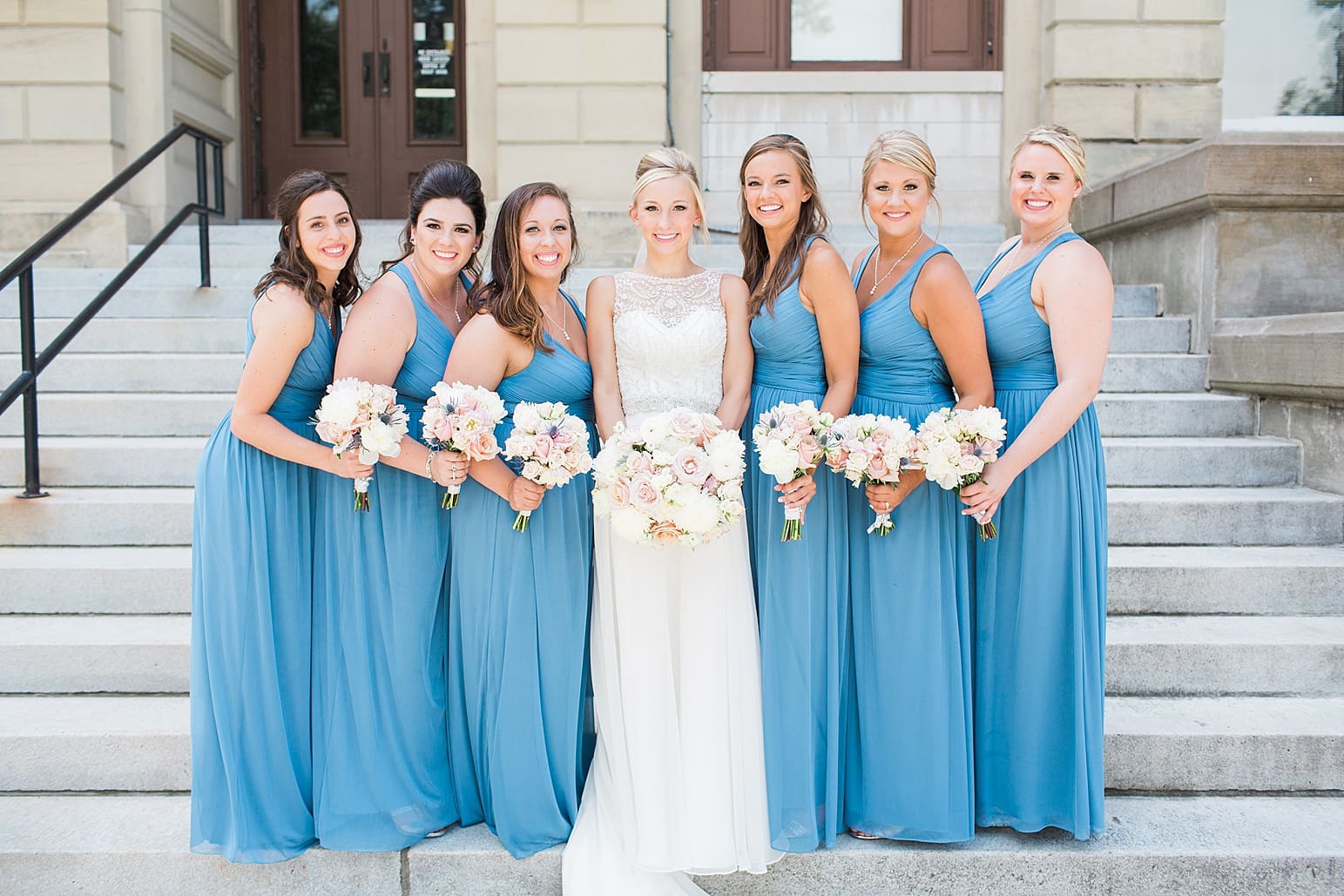 Arielle Peters Photography | Bride and bridesmaids standing on church steps on wedding day at the Spohn Ballroom in Goshen, Indiana.